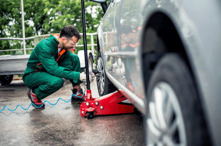 An auto mechanic is working on the tire rotation of the car to improve vehicle performance